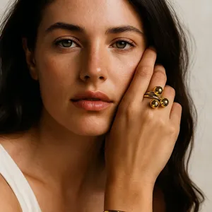 Primo piano dettagliato di un anello aperto minimalista dorato a sfere multiple elegante.
