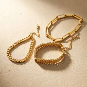 Detailaufnahme eines 3-teiligen goldenen Edelstahl-Armbandsets mit verschiedenen Ketten.