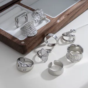 Gedetailleerde close-up van trendy zilveren metalen stapelbare ringen met geometrische vormen.