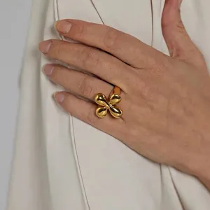 Primo piano del dettaglio dell'anello a trifoglio dorato indossato, accessorio retrò.