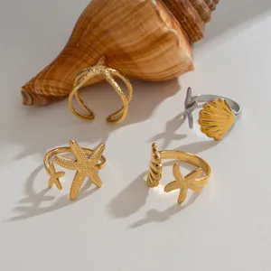 Nahaufnahme Detail von goldenen und silbernen Küsten Seestern Muschel offenen Ringen.