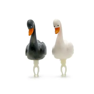 Close-up detail van zwart-witte schattige eend cartoon stofplug miniaturen op witte achter.