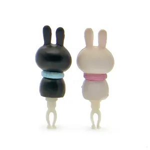 Close-up detail of cute rabbit couple dust plug, black and white design with colorful scarfs.