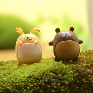Close-up detail of cute cartoon rabbit and animal figurines standing on moss surface.