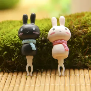 Cute couple rabbit headphone dust plug detail view, lovely resin accessory for smart devices.