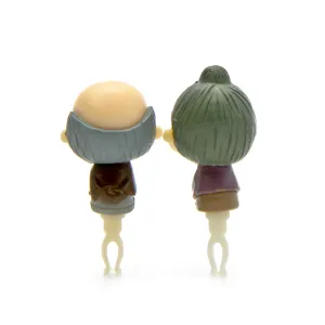 Detailed close-up shot of cute elderly couple cartoon character dust plugs for 3.5mm headphone jacks.