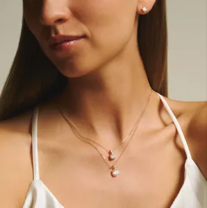 Elegante collar multicapa de acero titanio circonita con detalle de colgante brillante.