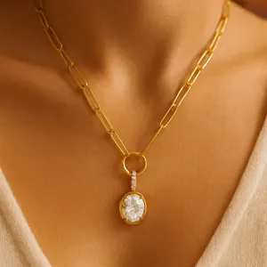 Primer plano detallado de un collar de cadena de eslabones dorados con colgante de cristal.