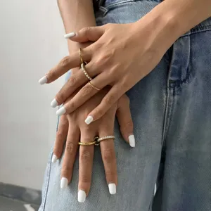 Primer plano detallado de elegantes anillos apilables dorados de acero inoxidable.