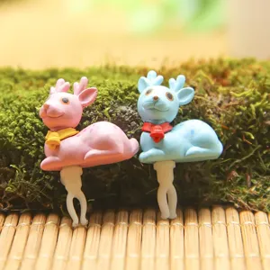 Close-up detail of cute cartoon deer couple 3.5mm dust plug charm, miniature accessories.
