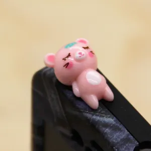 Süßer rosa Cartoon Bär Staubschutz Stecker Detailansicht, Harz Figur Smartphone Zubehör nah.
