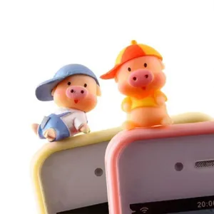 Détail de bouchon anti-poussière de cochon de dessin animé mignon, bel accessoire en résine.