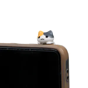 Cute calico cat dust plug figurine accessory showcased in a clear close up detail view.