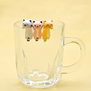 Close-up detail of cute hanging cat figurines on a glass rim, perfect decoration.