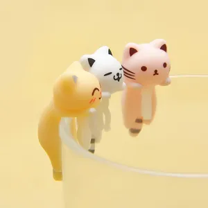 Cute cat cup hanging figurines close up, miniature resin animal decor for cute desk accessories.