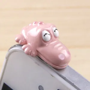 Cute pink cartoon crocodile headphone dust plug detail, 3.5mm jack charm accessory for phone.