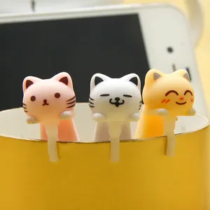 Cute cat dust plugs closeup detail showing three colorful cartoon kitty plugs hanging on a cup edge.