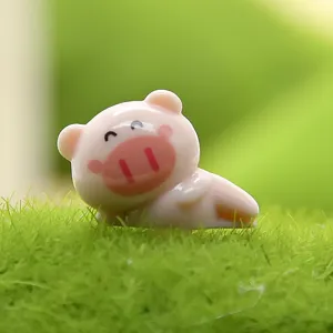 Close-up detailopname van een schattig roze varkensbeeldje op zacht groen kunstgras.