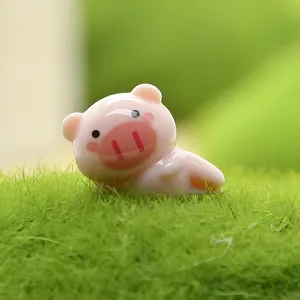 Gedetailleerde close-up van een schattig roze varkensbeeldje op groen kunstgrasveld.