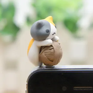 Close-up opname van een schattig driekleurig katten beeldje met een handig stofdop detail.