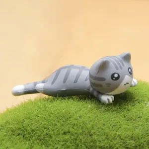 Grijs getijgerd kat figuurtje macro detail op groen mosoppervlak, schattig miniatuur ornament.