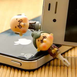 Close-up of cute cartoon old couple dust plugs for 3.5mm headphone jack accessory.