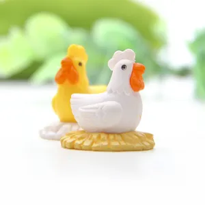 Vue en gros plan de figurine de poulet miniature pour micro paysage mousse succulente.