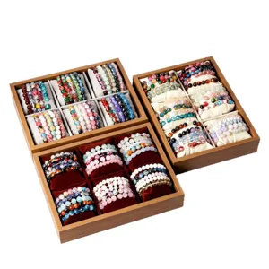 Walnut color wooden jewelry display tray with soft pillows for colorful gemstone beaded bracelets.