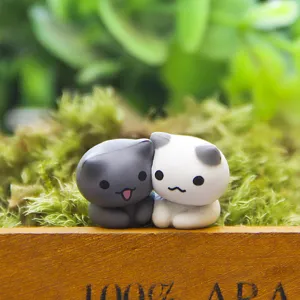 Close-up detailopname van schattige miniatuur kattenbeeldjes op mos, microlandschap.