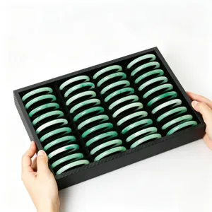 Boîte de rangement pour bracelets en velours noir avec plusieurs fentes pour bijoux et jade élégante.