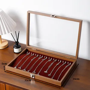 Notenhouten halsketting display tray met glazen deksel en rode fluwelen binnenkant voor sieraden.