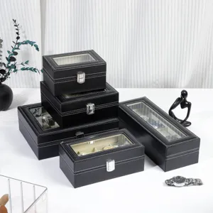 Black leather watch display box with clear glass lid and metal clasp, multi-grid storage case.