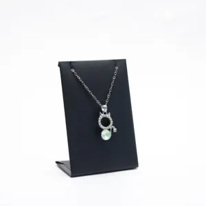 Silver cat necklace with rhinestone and opal pendant on black stand. Elegant jewelry gift.