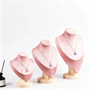 Ensemble de présentoirs de colliers en velours rose avec base en bois pour vitrine.