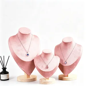 Ensemble de trois présentoirs de colliers en velours rose avec socles en bois pour vitrine.