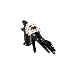 Colorful crystal beaded bracelets set displayed on black hand mannequin stand for elegant fashion.