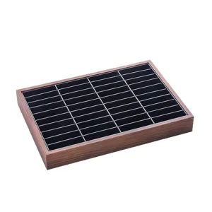 Walnut wood jewelry display tray with multi-slot grid organizer for earrings and rings.