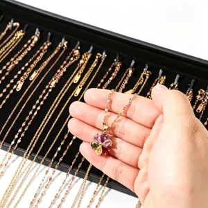 Collier avec pendentif fleur en pierre précieuse colorée sur plateau de présentation.