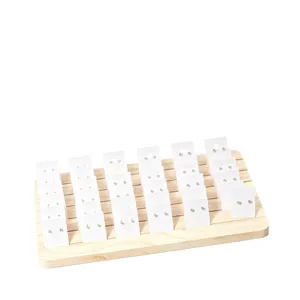 Houten oorbellen displaystandaard met witte kaarten voor sieradenorganisatie en presentatie.