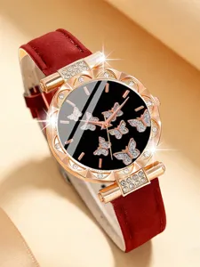 Dettaglio in primo piano dell'orologio da donna con quadrante a farfalla e cinturino.