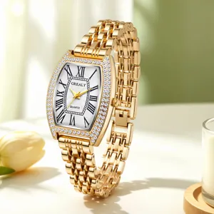 Montre quartz élégante pour femme avec cadran tonneau, lunette en strass et bracelet en métal doré.