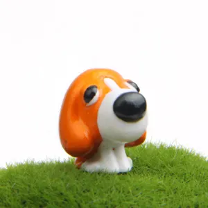 Gros plan d'une mignonne figurine de chiot en résine pour paysage miniature de jardin.