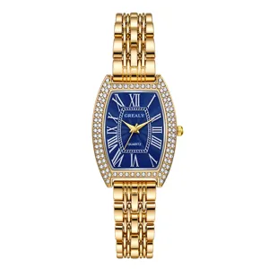 Détail de montre quartz tonneau dorée avec lunette en strass étincelante et cadran bleu.