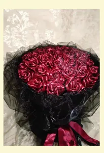 Handcrafted dark red ribbon rose bouquet wrapped in black glitter tulle for wedding decor.