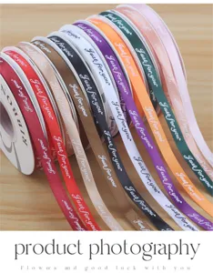 Detailed shot of colorful satin ribbon rolls with printed text for floral gift wrapping.