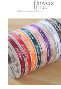 Close up of colorful fabric ribbons printed with english text for DIY floral and gift packaging.