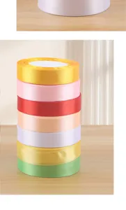 Close-up detail of colorful 2cm satin ribbons stacked together, perfect for floral gift wrapping.