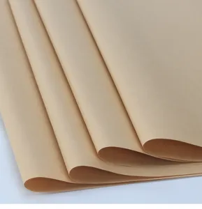Close up detail of natural brown kraft paper sheets, showing smooth texture and folded edges.