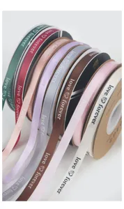 Detailed shot of colorful ribbon spools with love forever text, ideal for flower bouquet packaging.