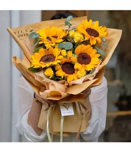 Detail view of beautiful sunflower bouquet wrapped in natural brown kraft paper for gifts.